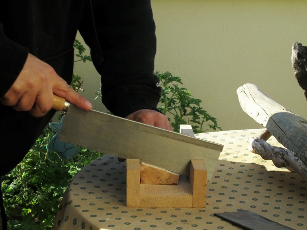 Seghetto manuale. Il pezzo di legno è tenuto fermo da una struttura anch'essa di legno