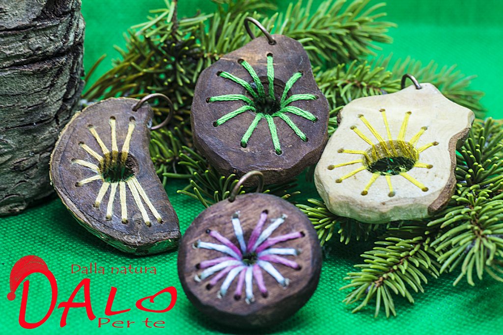 Idee per Natale. Ciondoli di legno con decoro con fili colorati di cotone lavorati a mano